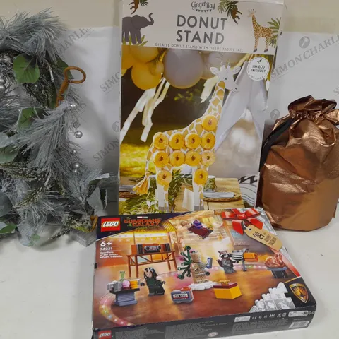 APPROXIMATELY 7 ASSORTED PRODUCTS TO INCLUDE; CHOCOHOLICS CHOICE GIFT HAMPER, LETS GO WILD GIRAFFE DOUGHNUT STAND, CADBURYS DAIR MILK CAR, LIT CONE GARLAND, RAVENHEAD ESSENTIALS FLOWER SET OF 2 AND GU