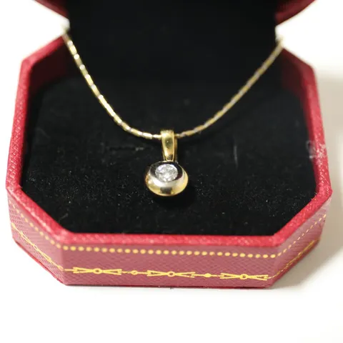 18CT GOLD PENDANT ON CHAIN, RUB-OVER SET WITH A NATURAL DIAMOND