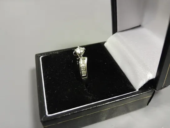 18CT WHITE GOLD TWIST RING SET WITH A NATURAL DIAMOND BAGUETTE SHOULDERS