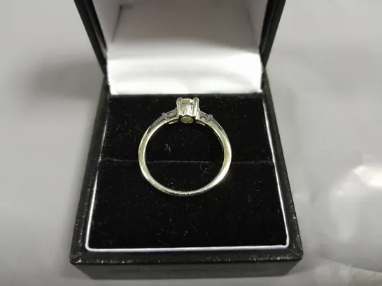 18CT WHITE GOLD RING SET WITH A NATURAL DIAMOND TO THE CENTRE AND A BAGUETTE TO EACH SHOULDER