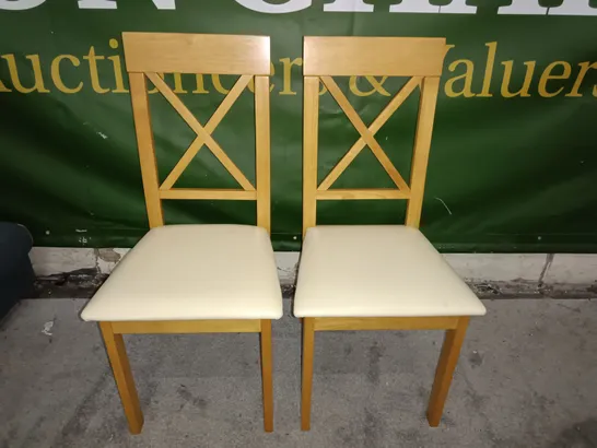 PAIR OF WOODEN CROSS BACK DINING CHAIRS WITH CREAM FAUX LEATHER SEAT PADS