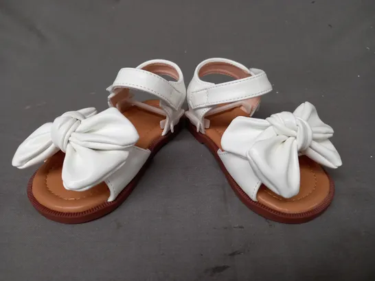 BOXED PAIR OF DESIGNER INFANT OPEN TOE SANDALS IN WHITE W. BOW DETAIL EU SIZE 20