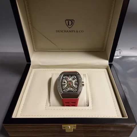 DESCHAMPS & CO MENS SILVER WATCH WITH SKELETON DIAL GLASS EXHIBITION BACK CASE AND RED RUBBER STRAP