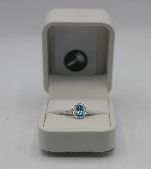 DESIGNER 9CT WHITE GOLD RING SET WITH AN OVAL BLUE TOPAZ TO DIAMOND HALO