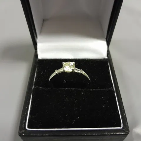 18CT WHITE GOLD RING SET WITH A NATURAL DIAMOND TO THE CENTRE AND A BAGUETTE TO EACH SHOULDER