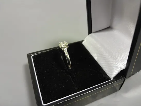 18CT WHITE GOLD RING SET WITH A NATURAL DIAMOND TO THE CENTRE AND A BAGUETTE TO EACH SHOULDER