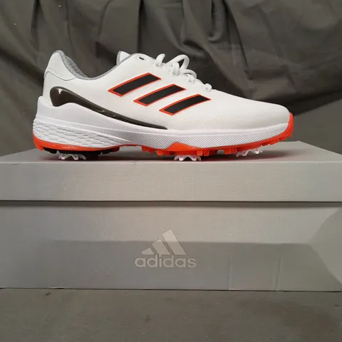 BOXED PAIR OF ADIDAS ZG23 GOLF SHOES IN WHITE/BLACK/ORANGE UK SIZE 7