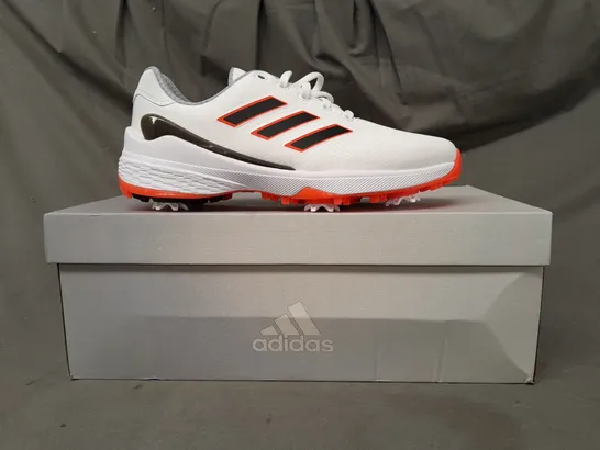 BOXED PAIR OF ADIDAS ZG23 GOLF SHOES IN WHITE/BLACK/ORANGE UK SIZE 7