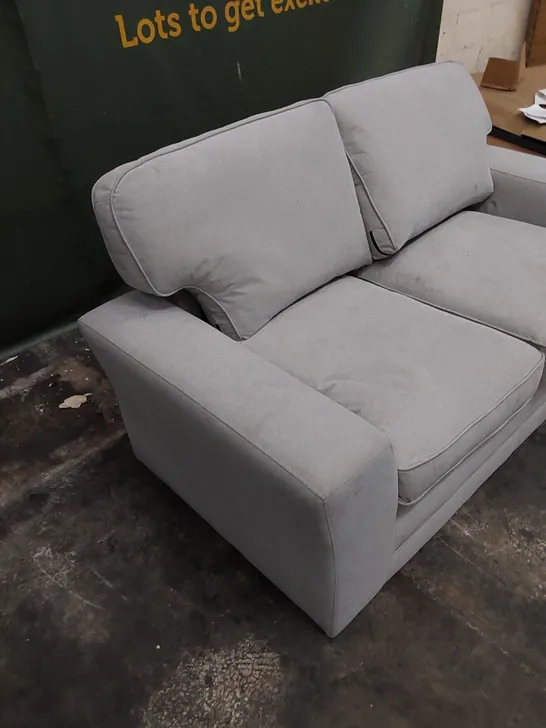 DESIGNER 2 SEATER UPHOLSTERED IN LIGHT COLOURED FABRIC 