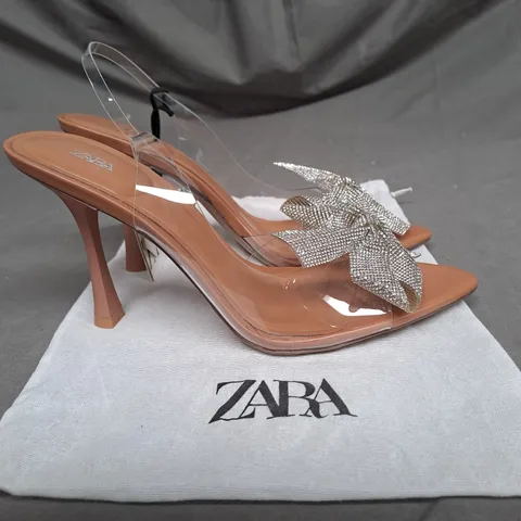 PAIR OF ZARA OPEN TOE HEELS IN CLEAR/TAN WITH SILVER BOW DETAIL SIZE 6