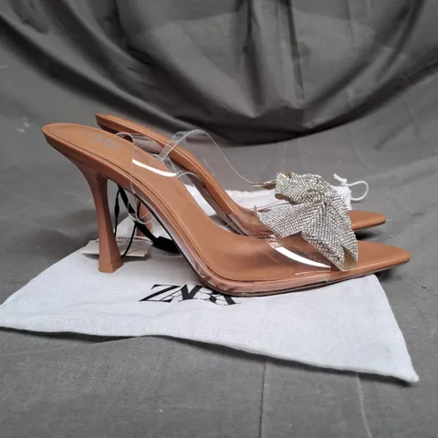 PAIR OF ZARA OPEN TOE HEELS IN CLEAR/TAN WITH SILVER BOW DETAIL SIZE 5