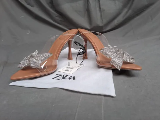 PAIR OF ZARA OPEN TOE HEELS IN CLEAR/TAN WITH SILVER BOW DETAIL SIZE 5