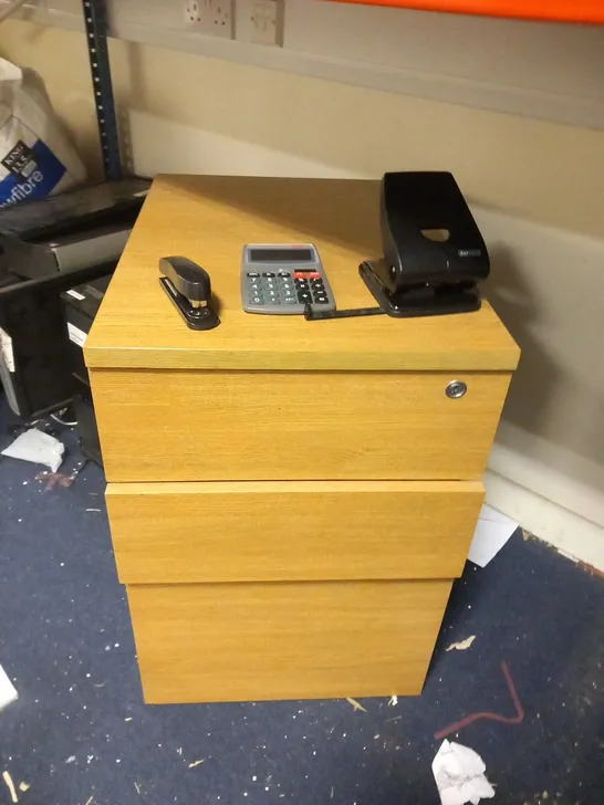 DESIGNER OAK EFFECT THREE DRAWER CABINET WITH STAPLER, HOLE PUNCH, CALCULATOR AND CLOCK