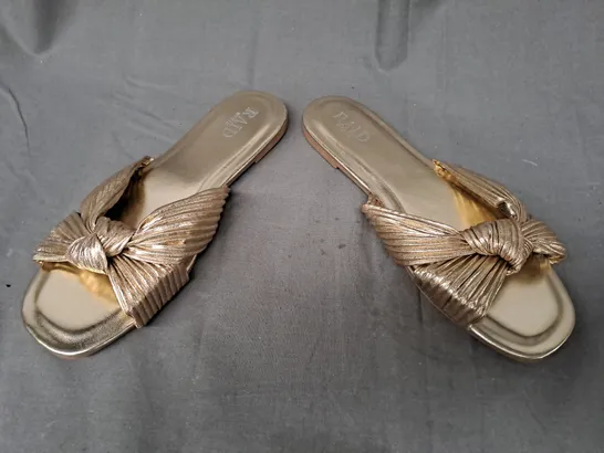 BOXED PAIR OF RAID LONDON OPEN TOE WIDE FIT FARAAH KNOT FLAT SANDALS IN METALLIC GOLD SIZE UNSPECIFIED