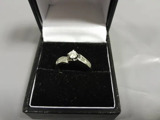 18CT WHITE GOLD TWIST RING SET WITH A NATURAL DIAMOND BAGUETTE SHOULDERS