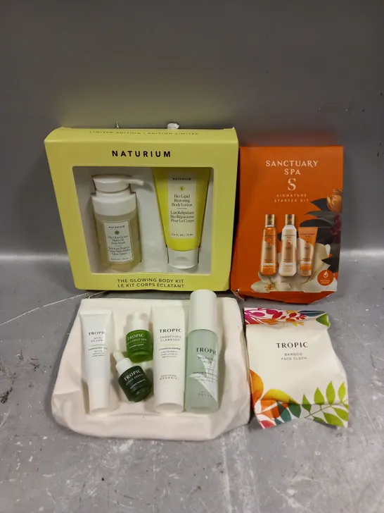 LOT OF 3 ASSORTED COSMETIC BOXSETS TO INCLUDE - NATURIM GLOWING BODY KIT - SANCTUARY SPA SIGNATURE STARTER KIT - TROPIC SKINCARE COLLECTION