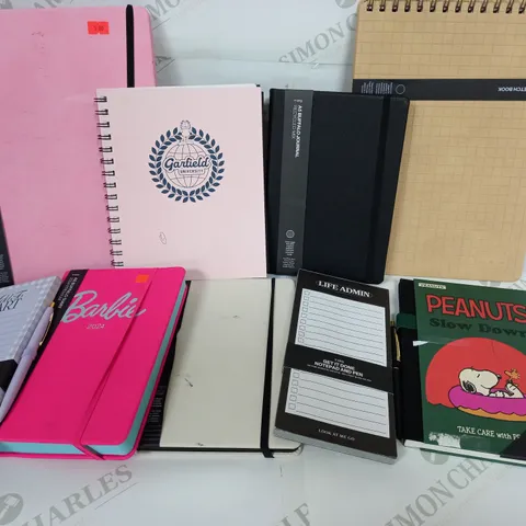 APPROXIMATELY 20 ASSORTED TYPO NOTEBOOKS, DIARIES, PLANNERS TO INCLUDE GARFIELD UNIVERSITY A5 CAMPUS NOTEBOOK, PEANUTS A5 FABRIC SPINE NOTEBOOK, BARBIE 2024 A5 DAILY DIARY 