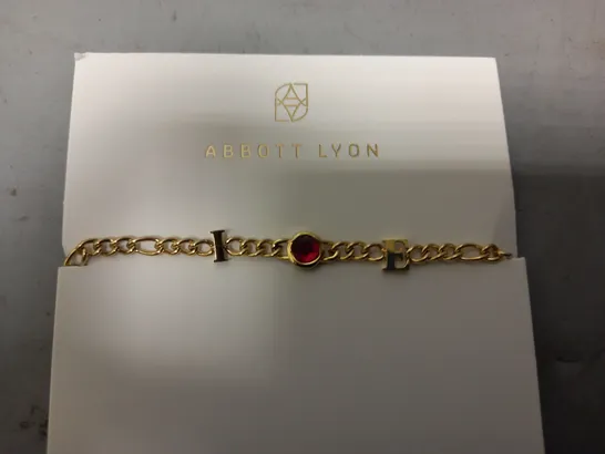 BOXED ABBOTT LYON CUSTOM INITIAL BRACELET IN GOLD W. RED JEWEL EFFECT