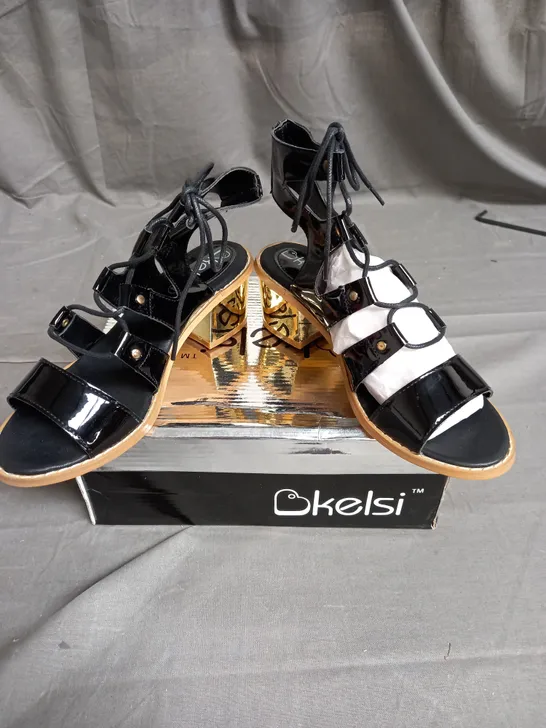 BOX OF 12 PAIRS OF KELSI STRAP HEELS IN BLACK/GOLD - VARIOUS SIZES