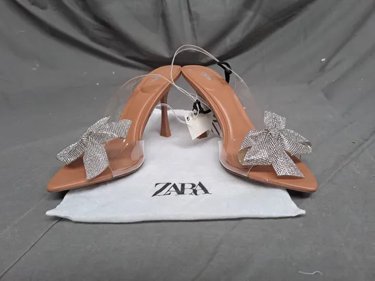 PAIR OF ZARA OPEN TOE HEELS IN CLEAR/TAN WITH SILVER BOW DETAIL SIZE 6