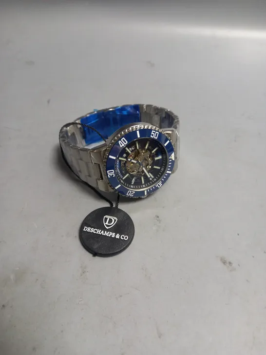 BOXED MENS DESCHAMPS & CO AUTOMATIC WATCH BLUE SKELETON DIAL AND A STAINLESS STEEL STRAP