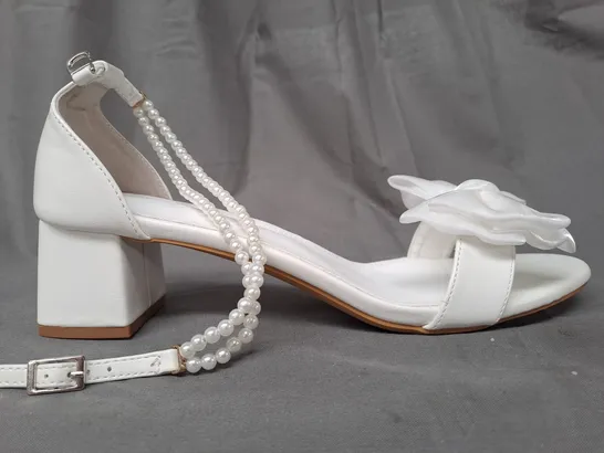 BOXED PAIR OF DESIGNER OPEN TOE BLOCK HEEL BRIDAL STYLE SANDALS IN WHITE W. BOW DETAIL AND PEARL EFFECT STRAP EU SIZE 44