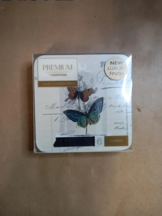 BOX OF APPROXIMATELY 70 PACKS OF CREATIVE TOPS CORK BACKED COASTERS IN A BUTTERFLY DESIGN 