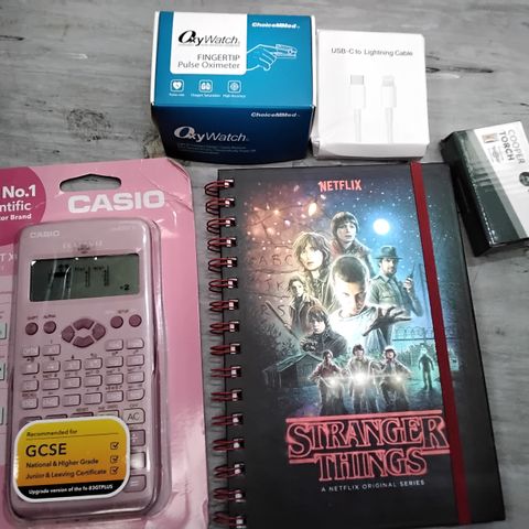 TOTE OF ASSORTED ITEMS INCLUDING CASIO SCIENTIFIC CALCULATOR, STRANGER THINGS NOTEBOOK, USB-C TO LIGHTENING CABLE, FINGERTIP PULSE OXIMETER, COOPER TORCH