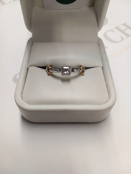 DESIGNER 18CT GOLD RING SET WITH A PRINCESS CUT DIAMOND TO THE CENTRE AND DIAMOND SET SHOULDERS