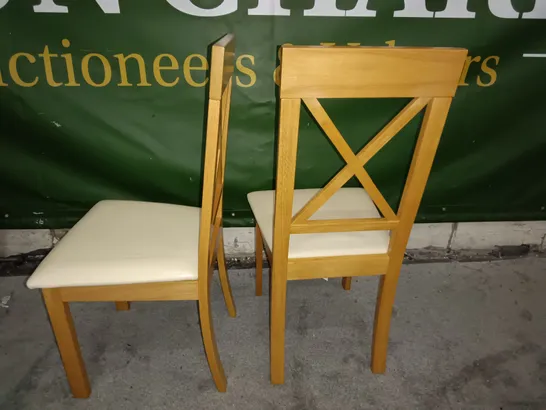 PAIR OF WOODEN CROSS BACK DINING CHAIRS WITH CREAM FAUX LEATHER SEAT PADS