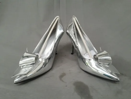 BOXED PAIR OF KAREN MILLEN TWIST BOW DETAIL POINTED TOE HEELS IN METALLIC SILVER SIZE 6