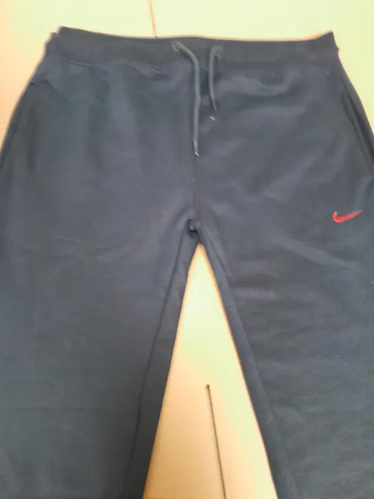 NIKE JOGGING BOTTOMS IN NAVY - SIZE LARGE