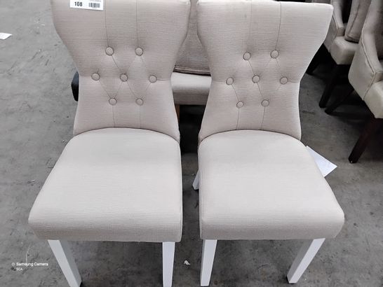2 DESIGNER CREAM FABRIC CHAIRS WITH BUTTONED BACK, AND WHITE LEGS