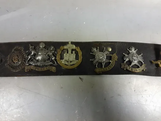 VINTAGE BELT WITH ASSORTED WW1/WW2 BRITISH ARMY CAP BADGES 