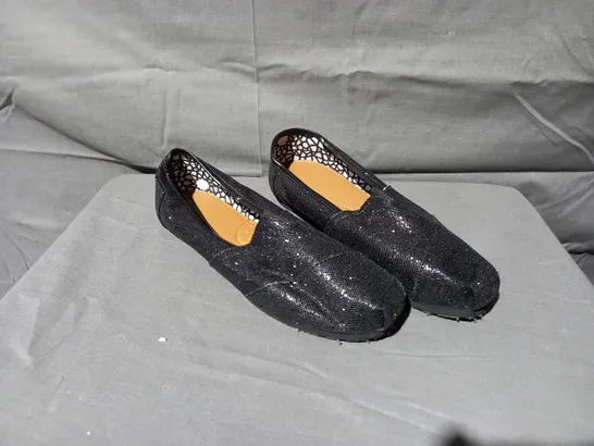 APPROXIMATELY 24 BOXED PAIRS OF FLAT SLIP ON SHOES IN BLACK GLITTER VARIOUS SIZES 6, 7, 8