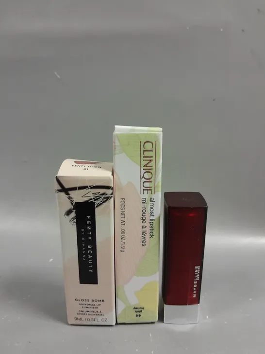 BOXED SELECTION OF THREE HEALTH AND BEAUTY PRODUCTS TO INCLUDE FENTY BEAUTY GLOSS BOMB IN 01 FENTY GLOW (9ML), CLINIQUE ALMOST LIPSTICK IN 44 PINK HONEY (1.9G) AND MAYBELLINE MATTE LIPSTICK IN 975 DIV