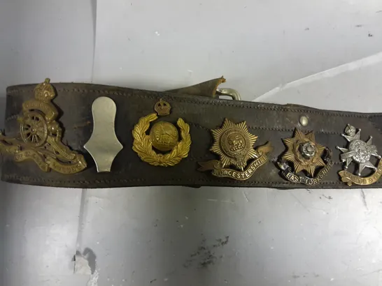 VINTAGE BELT WITH ASSORTED WW1/WW2 BRITISH ARMY CAP BADGES 