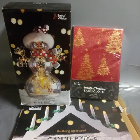 APPROXIMATELY 10 ASSORTED CHRISTMAS PRODUCTC TO INCLUDE SNOW WHITE LED CHRISTMAS ORNAMENT, CELE BRIGHT METALLIC CHRISTMAS TABLECLOTH, BATTERY OPERATED CANDLE BRIDGE, ETC