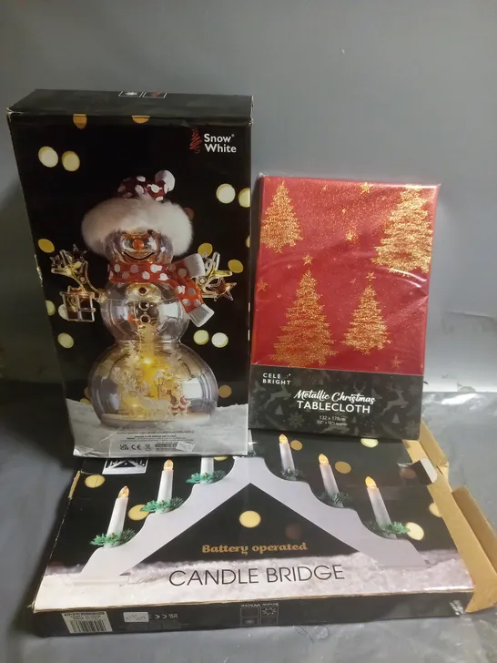 APPROXIMATELY 10 ASSORTED CHRISTMAS PRODUCTC TO INCLUDE SNOW WHITE LED CHRISTMAS ORNAMENT, CELE BRIGHT METALLIC CHRISTMAS TABLECLOTH, BATTERY OPERATED CANDLE BRIDGE, ETC