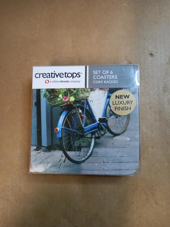 BOX OF APPROXIMATELY 50 CREATIVE TOPS SET OF 6 CORK BACK COASTERS IN A VINTAGE BICYCLE DESIGN