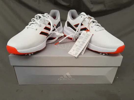 BOXED PAIR OF ADIDAS ZG23 GOLF SHOES IN WHITE/BLACK/ORANGE UK SIZE 7